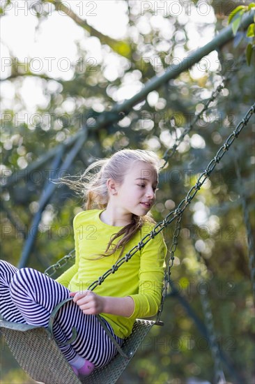 Caucasian girl sitting on swing