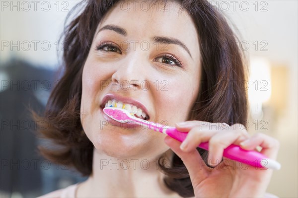 Close up of Hispanic woman brushing her teeth