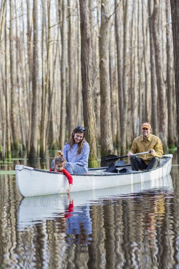 Family sitting together in canoe on river