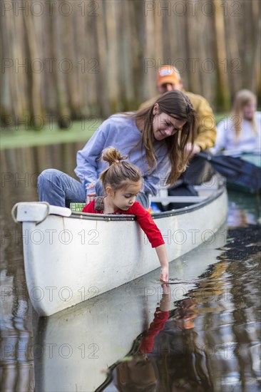 Family sitting together in canoe on river