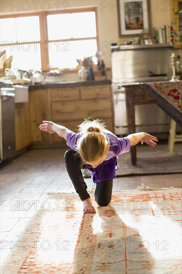 Caucasian girl dancing in kitchen