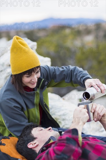 Couple sharing coffee on rock formations