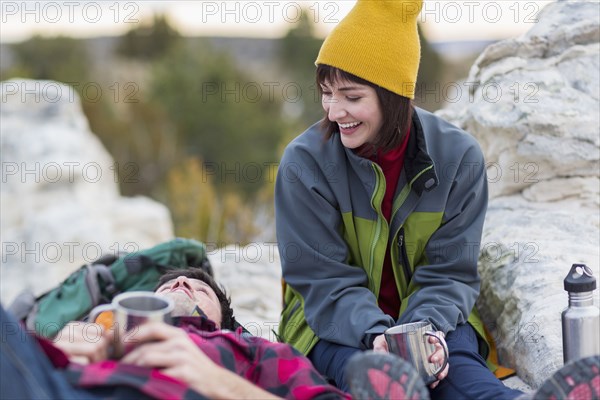 Couple sharing coffee on rock formations
