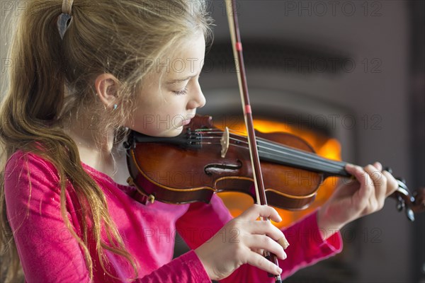 Close up of Caucasian girl practicing violin