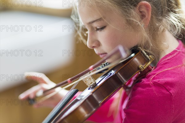 Close up of Caucasian girl practicing violin