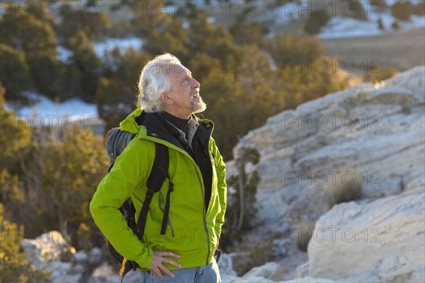 Older man standing on remote rock formations