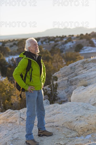 Older man standing on remote rock formations