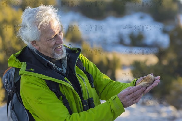Older man admiring rock on hike