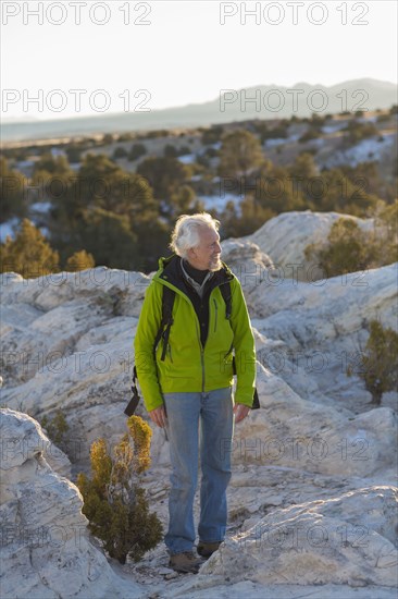 Older man standing on remote rock formations