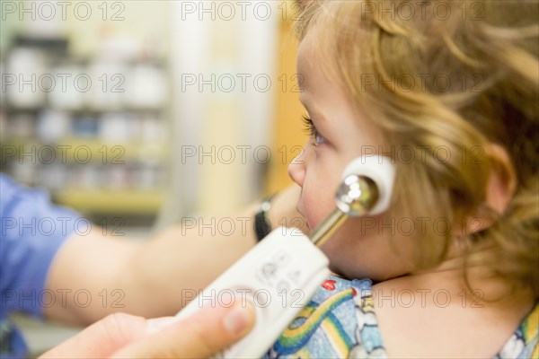 Close up of doctor taking temperature of boy with thermometer