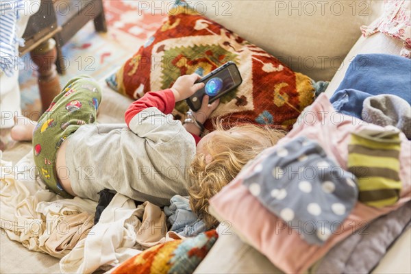 Caucasian boy using cell phone on sofa