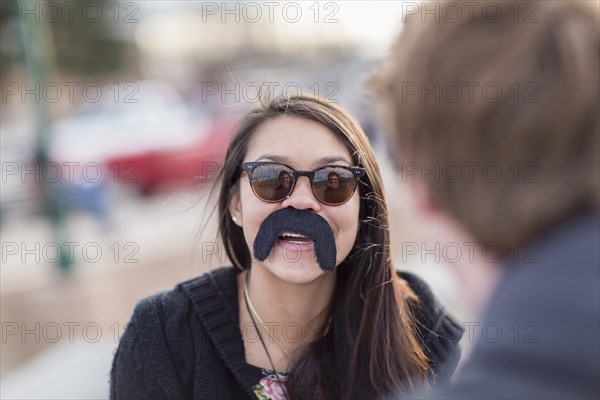 Teenage girl wearing fake mustache