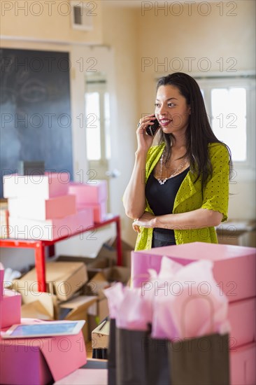 Mixed race businesswoman talking on telephone in office