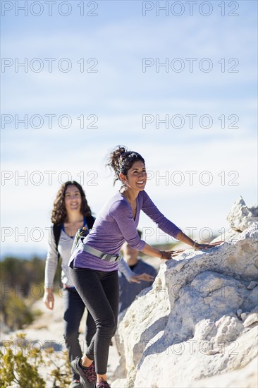 Hikers climbing rocky hillside