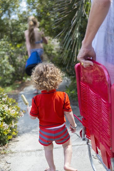 Caucasian family carrying deck chairs to beach