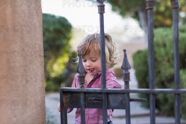 Caucasian baby boy playing at gate