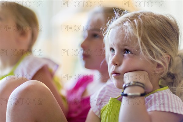 Caucasian girls watching television in armchair