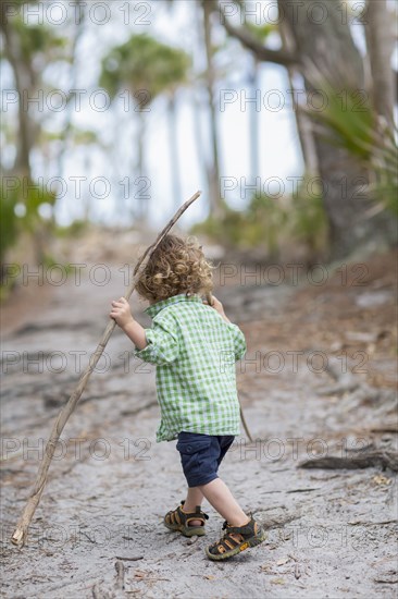 Caucasian baby boy walking on dirt path