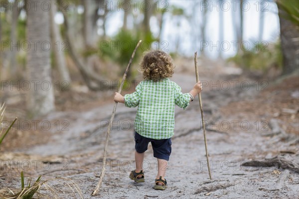 Caucasian baby boy walking on dirt path