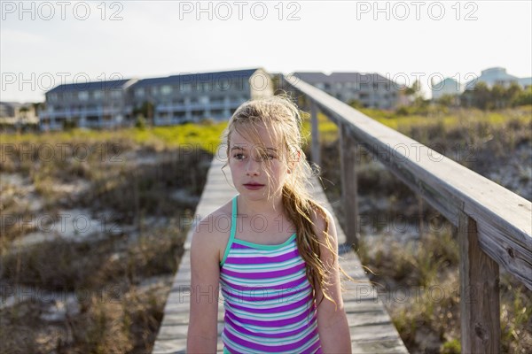 Caucasian girl on wooden walkway on beach