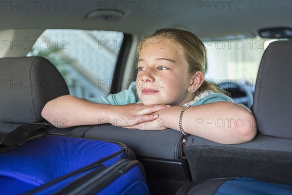 Caucasian girl sitting in car back seat on road trip