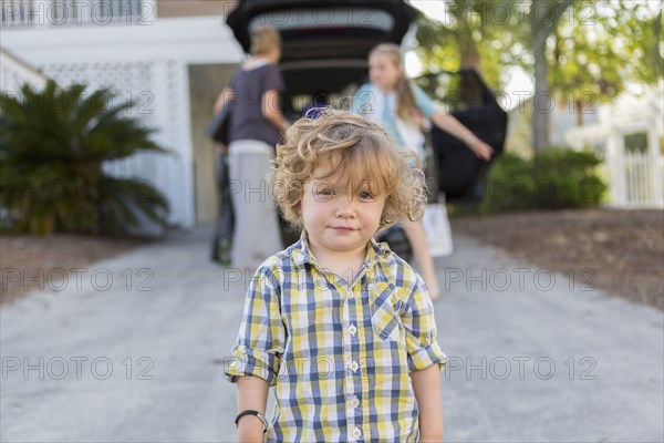 Caucasian baby boy standing in driveway