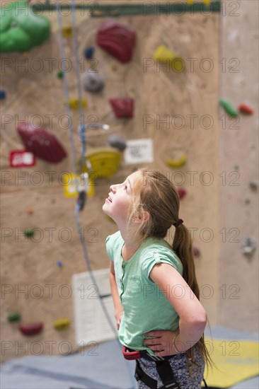 Caucasian girl examining rock wall indoors