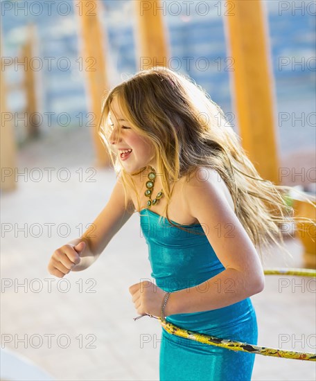 Caucasian girl playing with plastic hoop