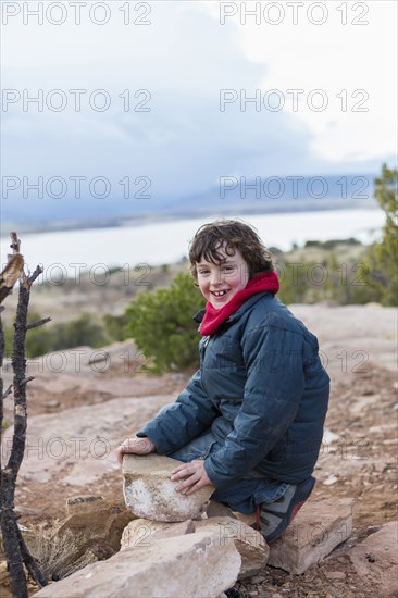 Boy examining rocks on dirt path
