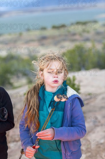 Caucasian girl toasting marshmallows at campfire