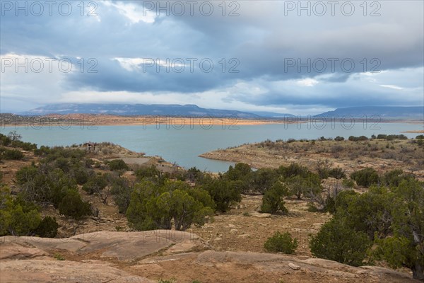 Desert landscape and river under cloudy sky