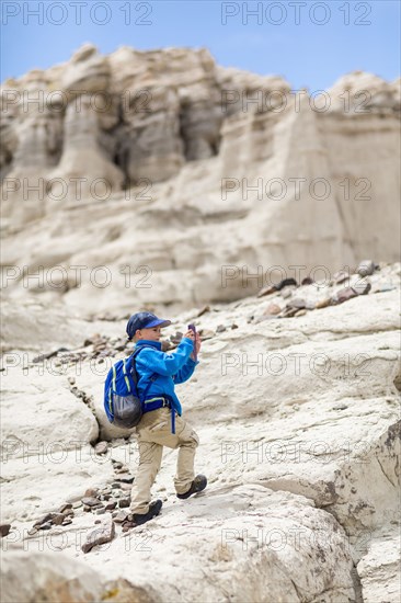 Boy photographing desert rock formations
