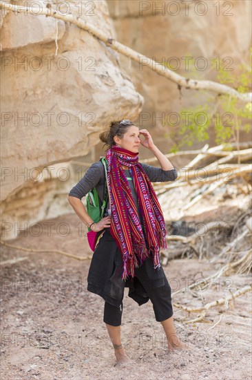 Mixed race hiker exploring desert rock formations barefoot