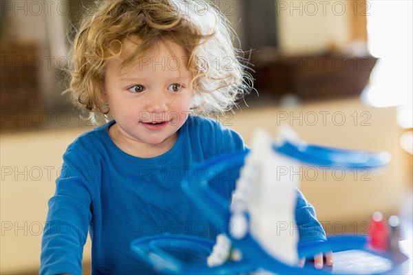 Caucasian baby boy playing with toy in living room