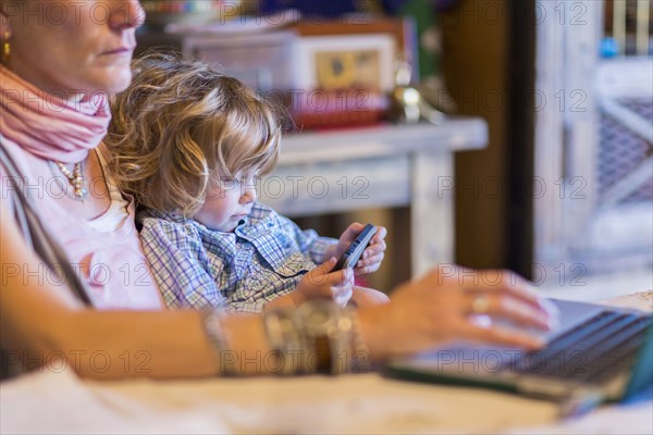 Caucasian mother and baby son using technology