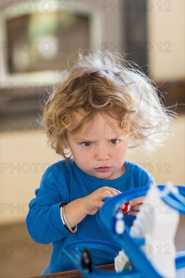 Caucasian baby boy playing with toy in living room