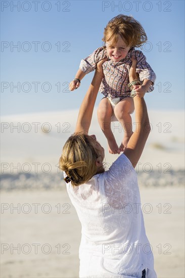 Caucasian mother and son playing in desert