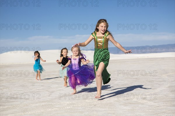 Girls walking on desert sand dunes