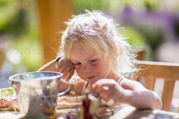 Caucasian girl playing with dolls at table