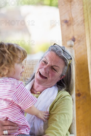Caucasian woman holding grandson in rocking chair