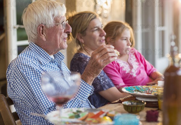 Caucasian family eating at table outdoors