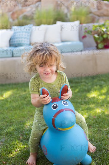 Caucasian baby boy playing with toy in backyard