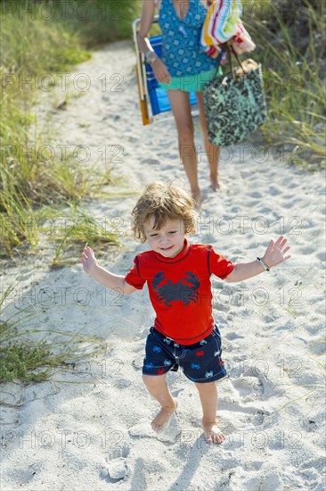 Caucasian mother and son walking on beach