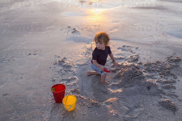 Caucasian baby boy playing on beach