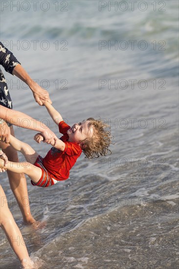 Caucasian family playing on beach