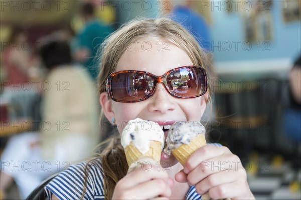 Caucasian girl eating two ice cream cones