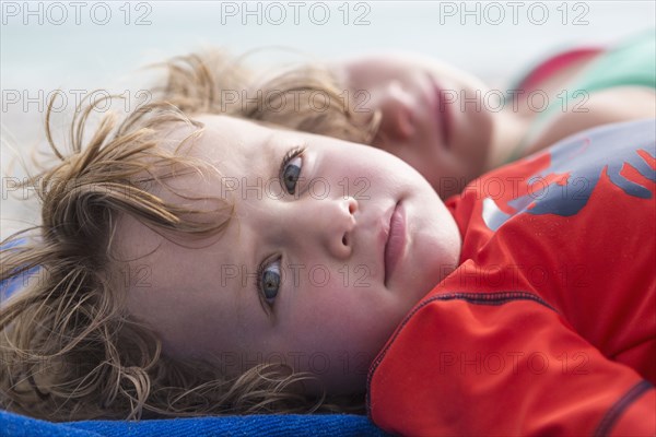 Caucasian baby boy laying on beach