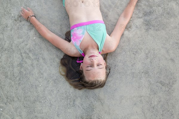 Caucasian girl napping on beach