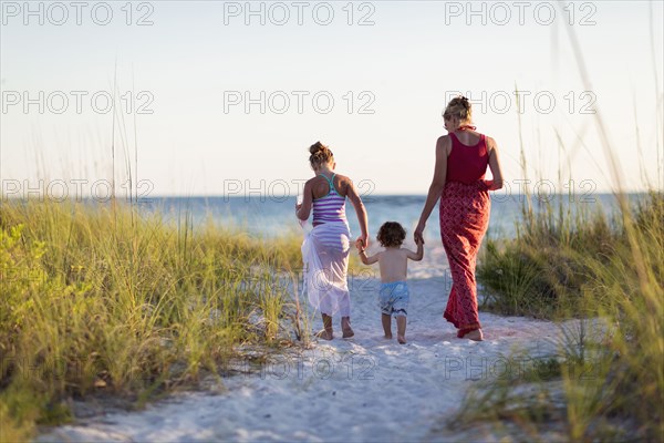 Caucasian mother and children walking on beach
