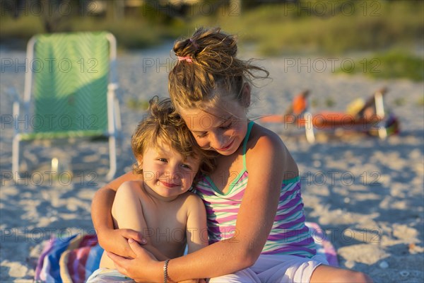 Caucasian children hugging on beach